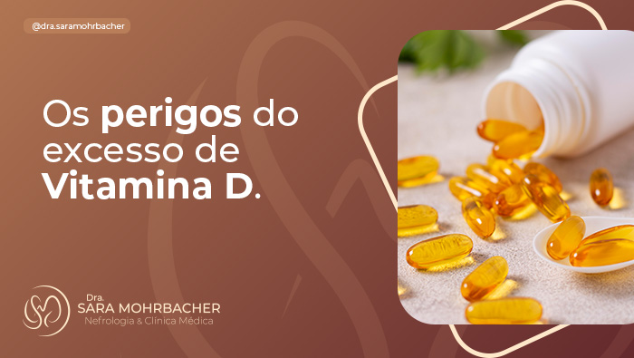 Cápsulas amarelas de suplemento vitamínico espalhadas ao lado de um frasco branco aberto sobre uma superfície clara, com um fundo desfocado de folhas verdes.